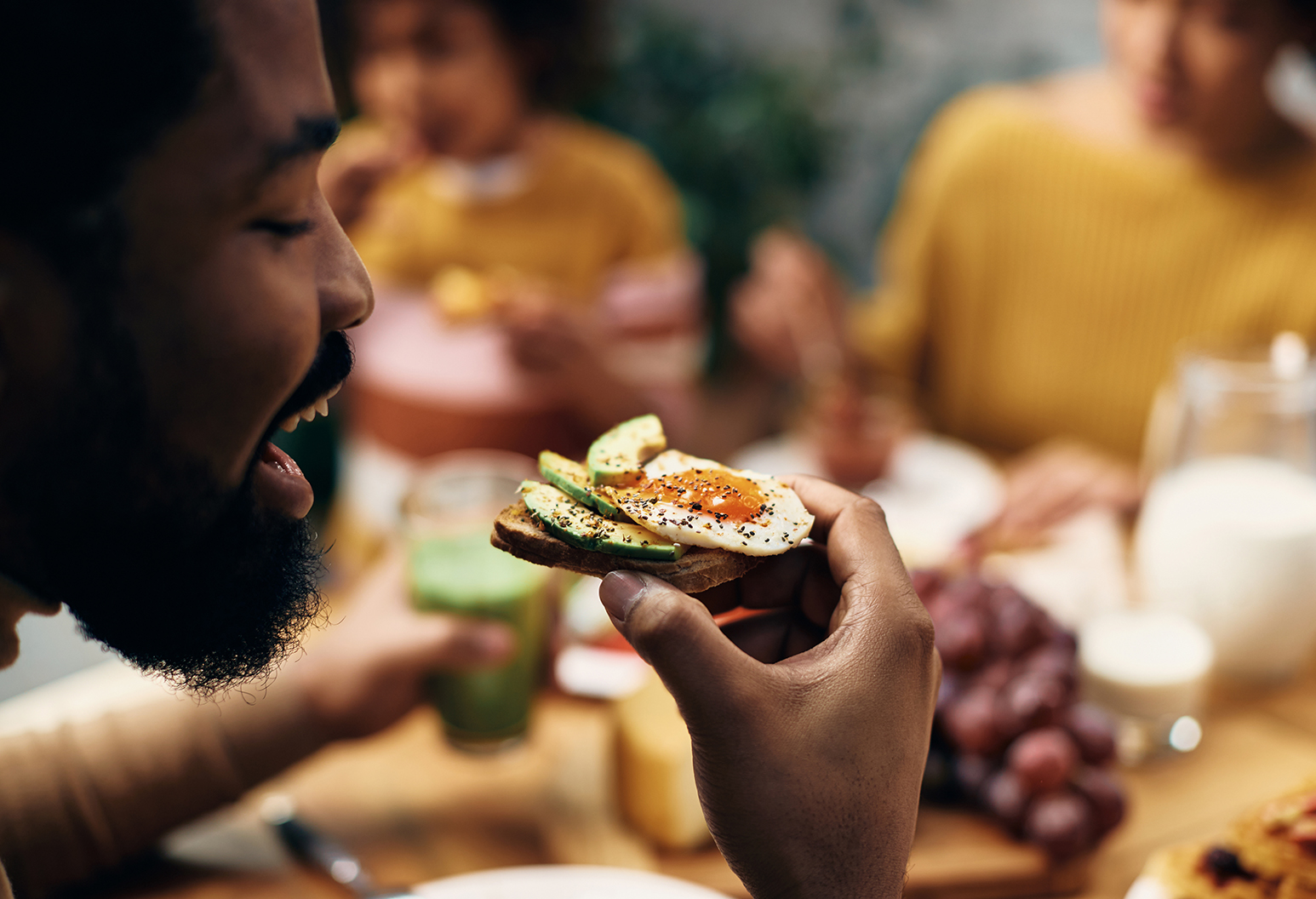 Close-up of black man eating healthy sandwich at home. - Mather Hospital